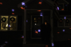 Danielle slips out for a cigarette among the Christmas lights after both kids are in bed. December 4, 2020. Rochester, NY.