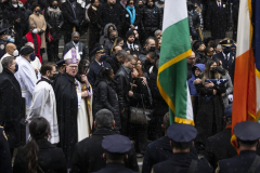 Dominique Luzuriaga (2-R), the widow of slain New York City police officer Jason Rivera, holds the flag from his casket as Jeffery Rivera (center right), his older brother, embraces their mother while mourners and clergymen, including Archbishop of New York Timothy Dolan (7-L) watch the funeral procession leave St. Patrick’s Cathedral following his funeral service in New York, New York, USA, 28 January 2022. Rivera, 22, was fatally injured on Friday 21 January when he and fellow officer Wilbert Mora, 27, who also died from his injuries, responded to a domestic violence call and were shot by man trying to escape.