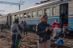 Anna Butenko (center right), aged, 26, from Dnipro, reacts as she holds her phone as an evacuation train of Ukrainian refugees from Lviv, Ukraine, to Przemysl, Poland, makes a random stop in the Ukrainian countryside. 13 March 2022.