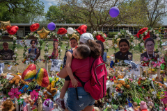 Connie Del Rio, from San Antonio, holds her son Rio, aged 2, as she looks at tributes outside of Robb Elementary School for the victims of the shooting, Uvalde, Texas. 30 May 2022.