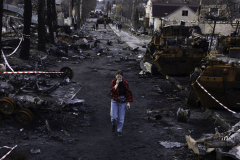A young girl reacts in shock as she walks amidst destroyed armored vehicles leftover from the battle for Bucha, Ukraine, on 4.7.22. Many Ukrainians returned to Bucha after the liberation to find their lives reduced to rubble. Even amidst the destruction, life goes on. Reality forces the young to bear the unfathomable burden of war, a responsibility they can not begin to comprehend.
