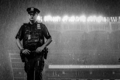 Police Officer John Davis stands in the driving rain during a rain delay when the New York Yankees played the Tampa Bay Rays Wednesday, Aug. 17, 2022, at Yankee Stadium in Bronx.