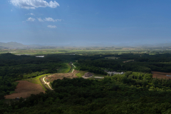 The 2.5-mile-wide DMZ cuts through the Korean Peninsula at its waist on June 3rd, 2023. Guards keep hills around their border fences denuded to increase visibility.  Seen from the sky, the Demilitarized Zone, or DMZ, looks like a gigantic geographical wound across the Korean Peninsula, the continuous wire fences snaking up the hills and down the valleys from coast to coast.