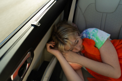 Eden Hoeffling, 17, sleeps in her mother's car as they drive to the Eagle Elite Cheerleading gym  in Columbia, Mo., from Sedalia on September 25, 2023. Eden’s disorder, Hypogammaglobulinemia, causes fatigue issues.