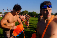 JERSEY CITY, NJ USA - AUGUST 19, 2023 -  After their mile run to start the event, people get their swimming gear ready while in Liberty State Park prior to swimming in NY Harbor.