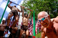 NEW YORK, NY USA - AUGUST 19, 2023 -  Near the end of the event, participants perform 22 pull-ups and a hundred push-ups near Ground Zero. In all, they each did 300 pushups and 66 pull-ups throughout the day and ended it when they visited the 9/11 Memorial Pools.