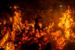 Hindu Priest Monu Panda jumps out of a 20-foot-high bonfire to signify the burning of the demon Holika during a ritual to mark the first day of Holi in the village of Phaelen, near Mathura, India. 08 March 2023.