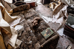 A teddy bear on a couch in a destroyed apartment building in Izyum, Ukraine on Monday, May 8, 2023.