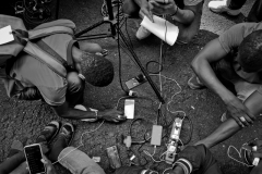 August 1,2023 Finding electricity was a challenge for the  migrants camping outside. A TV photojournalist helps them charge their phones.