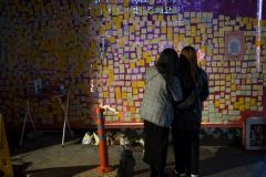 People paying their respect to the victims of the the 1029 Itaewon Crowd Crush Disaster at a temporary memorial set up at the alley where the crush happened last year in Seoul, South Korea, on Oct. 19th, 2023. The boarded up section will be a permanant memorial for the victims to remember them. It will be unveiled on Oct. 26th, 2023.