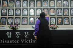 A mother touched her daughter’s picture at the temporary memorial for the victims of the 1029 Itaewon Crowd Crush Disaster, in front of Seoul city hall in Seoul, South Korea, on Oct. 23rd, 2023. The city still hasn’t provided or gave the familes permission to build a permanent memorial for the victims a year after the 1029 Itaewon Crowd Crush Disaster.