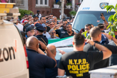 NYPD officers salute as the body of NYPD officer  Alexis Martinez, 26, at it is removed from his home into a waiting NYPD ambulance Wednesday, August 2, 2023 in the Bronx, New York. Officer Martinez was shot and killed by his father.