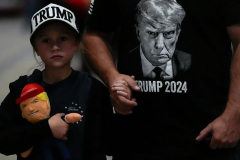 A young attendee holds a Donald Trump stuffed doll prior to Republican presidential nominee former President Donald Trump speaking at a campaign rally at Grand Sierra Resort and Casino, Friday, Oct. 11, 2024, in Reno, Nev.