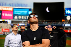 New York Yankees pitcher Carlos Rodón and other spectators watch the solar eclipse from Yankee Stadium. Monday, April 8, 2024 in Bronx, New York.