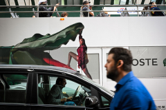AligatorTourists, a driver and a pedestrian are oblivious to the alligator lurking on a bus advertisement in NYC.