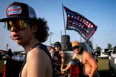 PILESGROVE, NJ USA - AUGUST 24, 2024 -  While tailgating hours before the start of the Cowtown Rodeo, Carter Evans, right, 19, holds the hand of his girlfriend Jaycee Di Stefano, 16, as she sits in the back of his pickup while with Dylan Cavanaugh, 16. They are from Bucks County, PA, and drove an hour to see the rodeo. He was proud to vote for Trump for the first time and show off his support because, as Evans says, “He’s the only man tough enough to lead America.” The Cowtown Rodeo is the oldest weekly rodeo in the country.