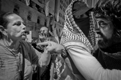 April 15, 24 Pro-Palestine protesters protest at the New York Stock exchange, Wall Street. Coordinated multi city disruption across the country. Supporters of Israel on the left and supporters of Palestine on the right in heated exchange as another protester tries to keep the two separate.