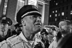 Sept 20,2024 Angry pro-Palestine protester holding a little-piggy-noise-maker in her hands shouts at a NYPD lieutenant.  Tweed Courthouse NYC