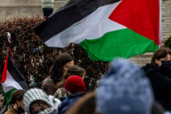 Pro-Palestinian students and activists camp out on the campus of Columbia University as others seen in the background pose in their caps and gowns ahead of graduation in New York City on April 19, 2024. Columbia students were the first to erect an encampment in support of Palestine, with students demanding that the school divest from Israel amid the Israel-Hamas war, where more than 34,000 Palestinians have been killed in the Gaza Strip.