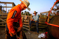 PILESGROVE, NJ USA - AUGUST 24, 2024 -  While behind the bucking chutes, Clovis Crane adjusts his chaps while preparing to compete in Bareback Riding.