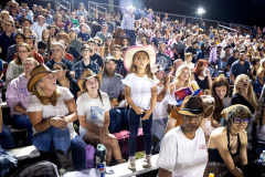 PILESGROVE, NJ USA - AUGUST 31, 2024 -  While in the stands of the arena, Hailey Smith, 5, of Newark, DE, reacts to the comedy act of Rodeo Clown Ronald Burton, of Philidelphia, MS, during a break in the competition. She is attending the rodeo with her mother Becki Woerner, left, and Anna Reese Woerner, 14.
