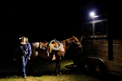 PILESGROVE, NJ USA - AUGUST 31, 2024 - A cowboy prepares his horse to leave at night’s end. Fans watch almost 3 hours of competition every week from May through October at the Cowtown Rodeo, the oldest weekly rodeo in the country.