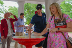 Horse racing fans take and taste samples from The Big Red Spring on the grounds of Saratoga Race Course before the 156th running of the Belmont Stakes horse race, Saturday, June 8, 2024, in Saratoga Springs, N.Y.
