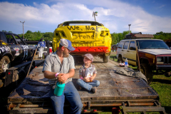 AUGUSTA, NJ USA - AUGUST 4, 2024 -  In the pit area before the heats, Doug Belina III looks up at his father, Doug Belina II, while snacking on goldfish crackers. He has been driving in demolition Derbys for the past ten years and hopes his son will follow. The first night of the Demolition Derby at the NJ State Fair held at the Sussex County Fairgrounds in Augusta.