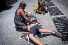 Please Don’t DieA street person and his dog try to revive an unconscious drug overdose victim on the street in the East Village in New York City.Intervention by the homeless man, the photographer and passerby likely saved the man from dying.
