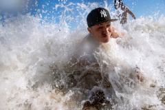 BROOKLYN, NY USA - AUGUST 23, 2025 - On the first day the beach in Coney Island was open after rough surf from Hurricane Erin closed it, a bather is tossed around in the water. Lifeguards kept people close to the shore, and fortunately, Coney Island rarely experiences riptides.