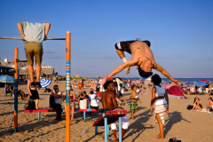 BROOKLYN, NY USA - JULY 4, 2025 - People work out out on the athletic bars on the beach in Coney Island on the 4th of July Independence Day holiday.