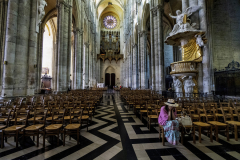A woman alone in prayer in the vast cathedral in Amiens in France, April 29, 2025.