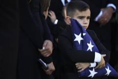 EA: Saed Hindash – NJ Advance Media/lehighvalley.com – Left Behind - Luke Marino, son of Officer Brett Marino, clutches the American flag that had been draped across his father’s casket after a memorial service at Phillipsburg High School on Oct. 18, 2025.