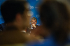 PHILIPPE LAZZARINI, Commissioner-General of UNRWA, seen through journalists in the foreground, listens to questions in the United Nations press briefing room. The briefing addressed challenges facing the agency and humanitarian aid operations in the region.