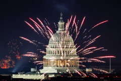 Illegal fireworks in DC neighborhoods frame the U.S. Capitol in colorful light after the official fireworks ended on the National Mall in Washington, DC on Friday, July 4, 2025.