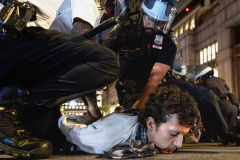 NEW YORK, NY USA - JUNE 10, 2025 - A pair of NYPD officers arrest an unconscious protester outside Federal Plaza in Lower Manhattan. The protester was injured in a violent squirmish as people tried to stop Department of Homeland Security vans from leaving Federal Plaza to transport immigrants to a bigger detention facility in NJ. There were 86 arrests on a violent night in Lower Manhattan.