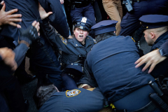 NEW YORK, NY USA - MARCH 10, 2025 - After chasing the suspect down, a New York City police officer looks up at her colleagues after falling while wrestling a protester during an arrest at a march in support of Mahmoud Khalil, a Columbia graduate and Palestinian activist who helped lead student protests. Khalil was arrested by Immigration and Customs Enforcement but was later released and is fighting deportation in the American court system.