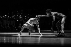 Phillipsburg students wave their cell phone lights in the background as Anthony Ashford and Warren Hills’ Tyler Redfield (white) wrestle at 138 pounds on Jan. 27, 2025.