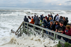 People run from the water as waves crash on the shore of Smith Point Beach in Shirley as Hurricane Erin moves up the eastern seaboard, Thursday, Aug. 21, 2025.