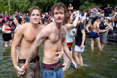 NYC Pride Couple - NEW YORK, NY, USA - JUNE 29, 2025 - A pair of men cool off on a hot summer day in the Washington Square Park fountain while celebrating after the 2025 New York City Pride parade in Manhattan. The celebration is the largest gay rights event in the world, with around 2.5 million participants. Gay rights have become a political flashpoint with Republicans running on banning classroom instruction of sexual orientation and gender identity, restricting gender-affirming care, and disallowing transgender girls to play in women's sports. New York City is the modern birthplace of gay rights ever since 1969, when police raided the gay bar the Stonewall Inn, and 6 days of protests resulted afterward.